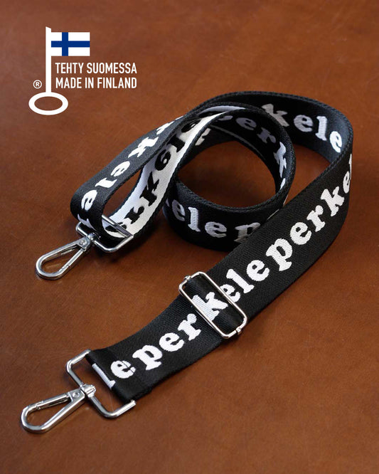 Black lanyard with white text on a brown surface, featuring the brand perkele.
