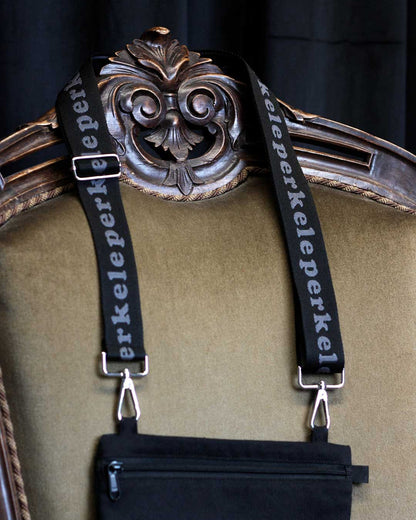 Decorative frame with ornate design and 'perkele' purse strap on a dark background